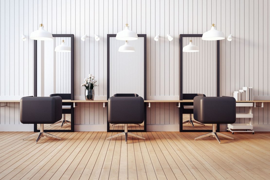 3 empty barbering chairs in a salon
